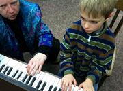 young boy at piano lesson with teacher