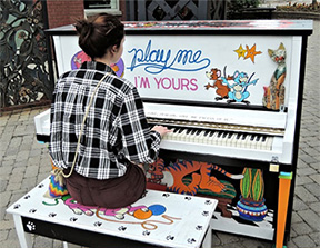 man playing a street piano